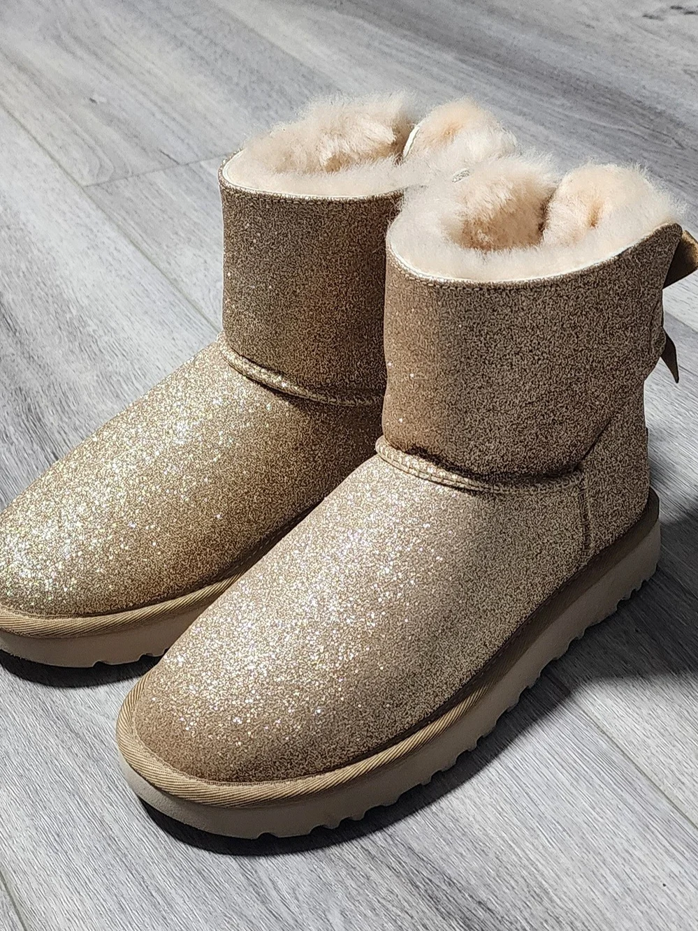 NWOB UGG Mini Bailey Bow Gold Sparkle Boots W/ Sheepskin Lining Womens Size 7